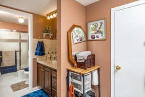 Full bathroom featuring combined bath / shower with glass door, a textured ceiling, vanity, tile patterned flooring, and toilet