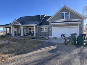 View of front of property featuring a garage and covered porch