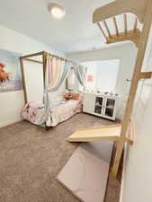 Bedroom featuring carpet floors and a textured ceiling