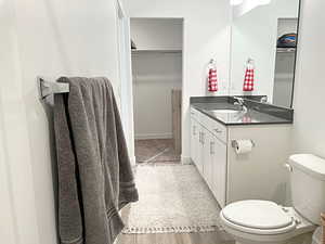 Bathroom with toilet, vanity, and hardwood / wood-style flooring