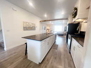 Kitchen with sink, white cabinets, stainless steel appliances, and light wood-type flooring