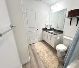 Bathroom featuring hardwood / wood-style floors, vanity, and toilet