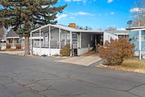 Manufactured / mobile home with covered porch and a carport