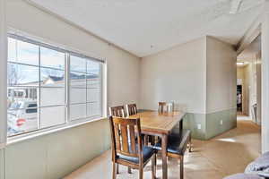 Carpeted dining area with a textured ceiling