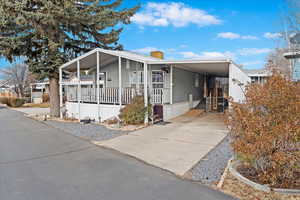 Manufactured / mobile home featuring a carport and covered porch