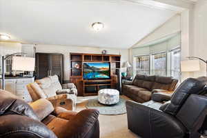 Carpeted living room featuring a textured ceiling and lofted ceiling