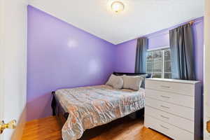 Bedroom with a textured ceiling and light wood-type flooring