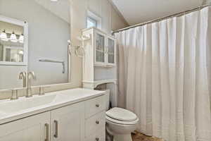 Bathroom featuring hardwood / wood-style flooring, vanity, a textured ceiling, and toilet