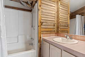 Bathroom featuring vanity and shower / tub combo with curtain