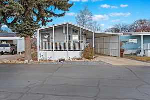 Manufactured / mobile home featuring a carport and a porch