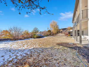 Snowy yard featuring a patio area