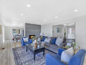 Living room featuring a fireplace, light hardwood / wood-style flooring, and ceiling fan