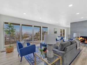 Living room featuring a fireplace, light hardwood / wood-style floors, and a wealth of natural light