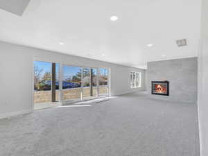 Unfurnished living room featuring light carpet