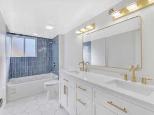 Full bathroom with tile patterned floors, vanity, toilet, and tiled shower / bath