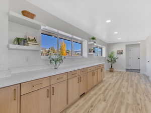 Kitchen with light brown cabinetry and light hardwood / wood-style flooring