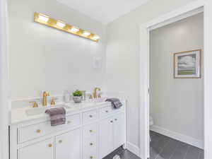 Bathroom featuring tile patterned flooring, vanity, and toilet