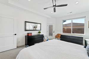 Carpeted bedroom featuring ceiling fan