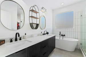 Bathroom featuring a bathtub, vanity, tile patterned flooring, tile walls, and a baseboard radiator