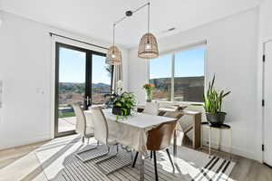 Dining area with a mountain view, plenty of natural light, and light wood-type flooring