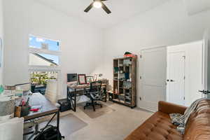 Carpeted home office featuring ceiling fan