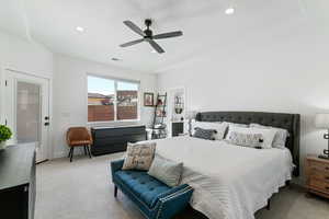 Primary bedroom featuring light colored carpet and ceiling fan