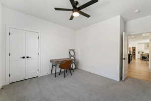 Interior space with ceiling fan and light carpet