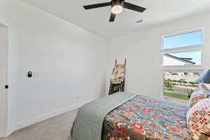 Bedroom with ceiling fan and light carpet