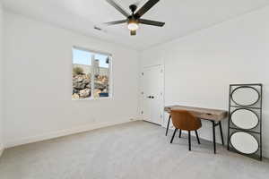 Carpeted office featuring ceiling fan