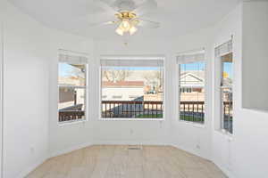 Unfurnished room featuring plenty of natural light and ceiling fan