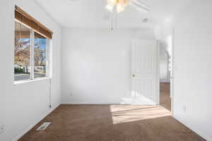 Empty room featuring carpet floors and ceiling fan