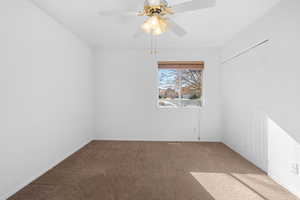 Carpeted spare room featuring ceiling fan