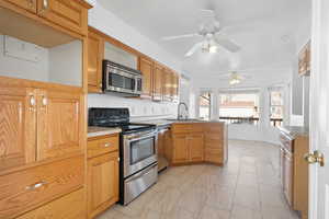 Kitchen featuring kitchen peninsula, ceiling fan, sink, and stainless steel appliances