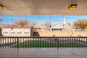 Wooden terrace with a lawn and a storage shed