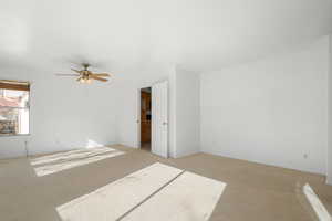 Empty room featuring light colored carpet and ceiling fan