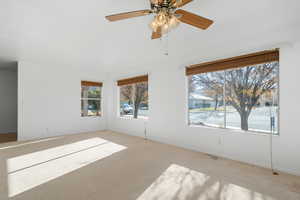 Carpeted empty room with ceiling fan