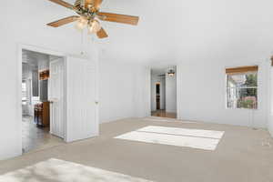 Interior space with light carpet and ceiling fan