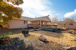 Rear view of property featuring a storage unit