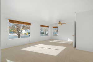 Empty room with light colored carpet and ceiling fan