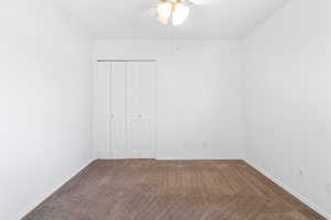 Unfurnished bedroom with carpet flooring, ceiling fan, and a closet