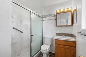 Bathroom with vanity, toilet, and walk in shower