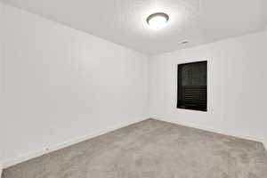 Carpeted spare room featuring a textured ceiling