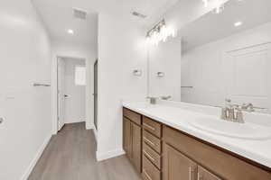 Bathroom featuring hardwood / wood-style floors, vanity, and a shower with door