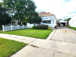 View of front facade featuring a garage, an outbuilding, and a front yard