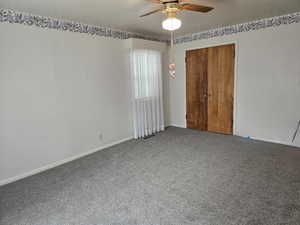 Carpeted spare room with ceiling fan