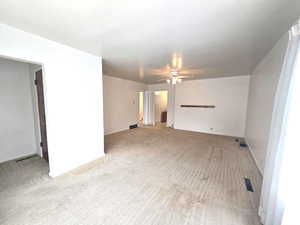 Carpeted empty room featuring ceiling fan