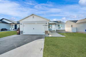 Single story home with a garage and a front lawn