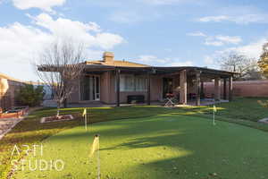 Rear view of house featuring a patio area and putting green