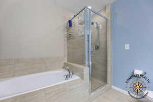 Primary Bathroom featuring tile patterned floors and shower with separate bathtub