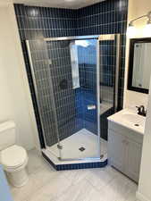 Bathroom with toilet, vanity, and walk in shower